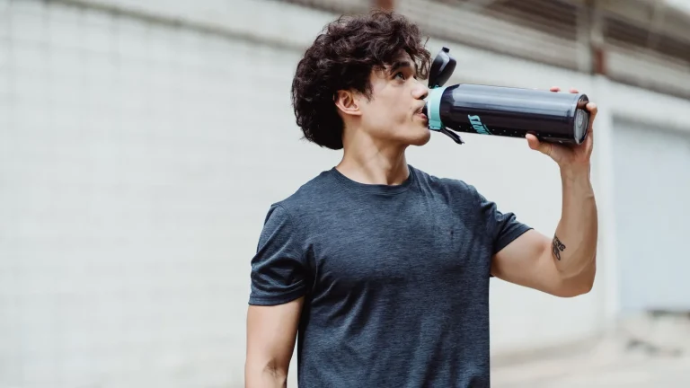 Un sportif boit à sa gourde après l'effort