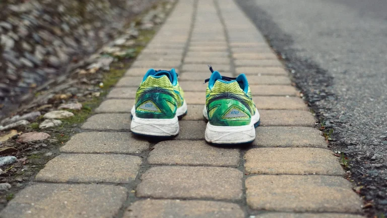 Une paire de chaussures de running posée sur un chemin pavé