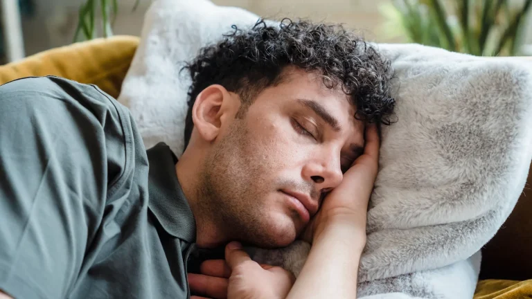 Un homme fait la sieste sur un canapé