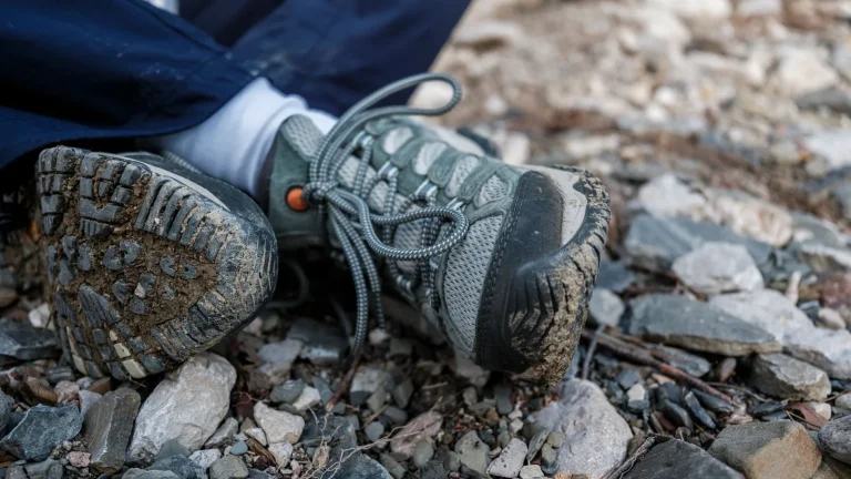 Une chaussure de trail à semelle crantée sur un sentier de cailloux