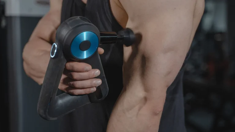 Un sportif utilise un pistolet de massage sur le bras