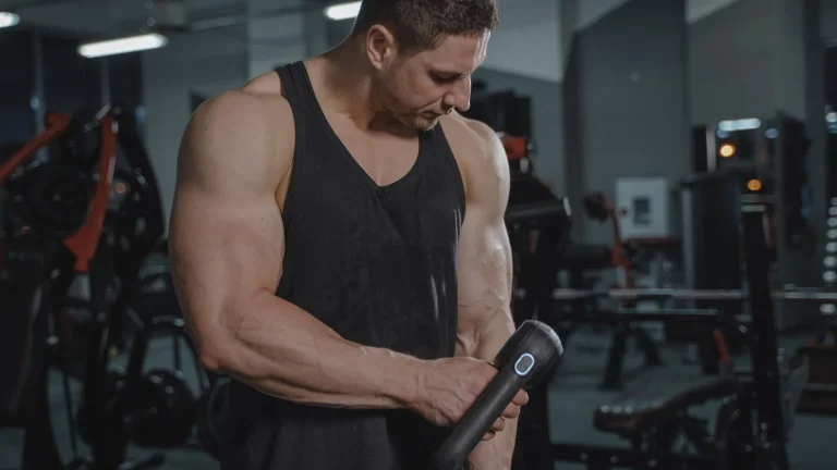 Un sportif se masse l'avant-bras avec un pistolet de massage
