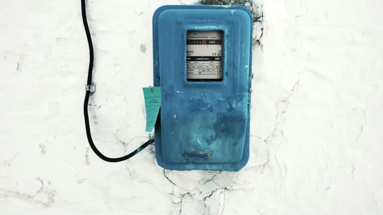 Un compteur électrique fixé sur un mur, symbole de la facture d'énergie