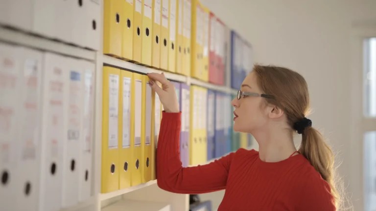 Des boîtes d'archives et classeurs rangés sur des étagères pour conserver ses papiers