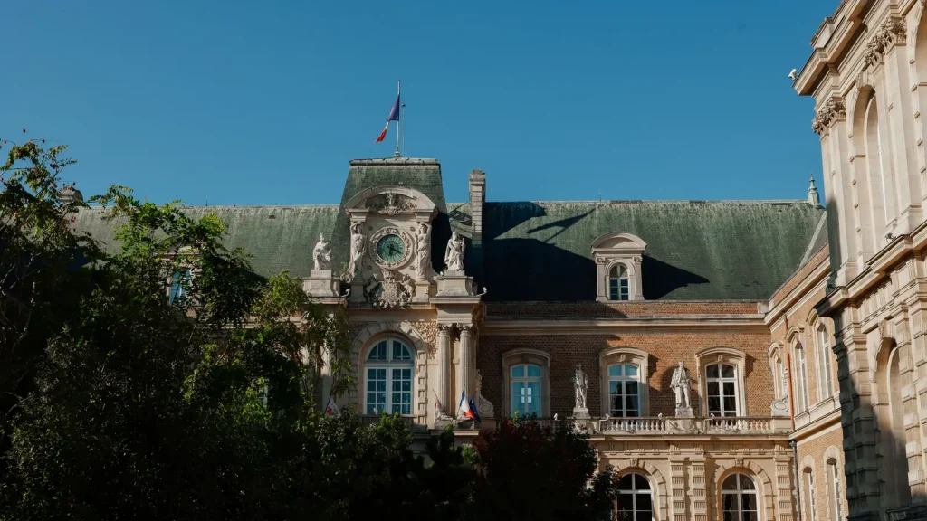 Façade d'un édifice historique français surmonté d'un drapeau tricolore